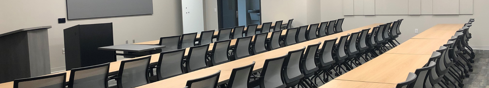 Image of meeting tables, chairs and screen